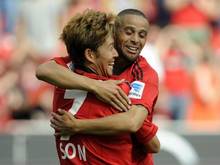 Heung-Min Son (l) und Sidney Sam jubeln über ein Tor für Bayer Leverkusen. Foto: Marius Becker