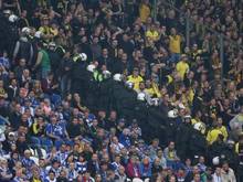 Eine Polizeikette trennt die Fanblocks von Schalke und Borussia Dortmund