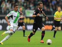Der Wolfsburger Luiz Gustavo (l) im Laufduell mit dem Augsburger Halil Altintop. Foto: Jens Wolf