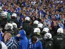 Polizisten gehen beim Spiel Schalke gegen Saloniki zwischen die Fußballfans