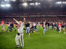 Die Fans des 1. FC Köln stürmen nach dem Spiel den Rasen. Foto: Marius Becker