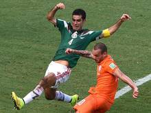 Der Mexikaner Rafael Márquez (l) attackiert bei der WM den Niederländer Wesley Sneijder. Foto: Vassil Donev