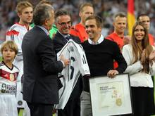 Philipp Lahm (r) nimmt eine Ehrung von DFB-Präsident Wolfgang Niersbach (l) entgegen. Foto: Roland Weihrauch
