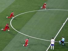 Belgische Spieler und Schiedsrichter Antonio Mateu Lahoz knien vor dem Spiel gegen Russland