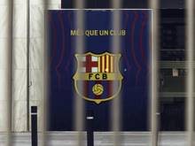Blick auf das Wappen des FC Barcelona hinter den geschlossenen Toren des Camp Nou Stadions