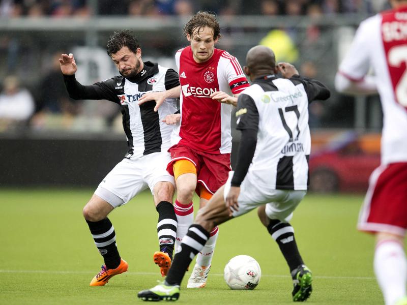 Daley Blind (M) von Ajax Amsterdam nimmt es gleich mit zwei Gegenspielern an. Foto: Olaf Kraak