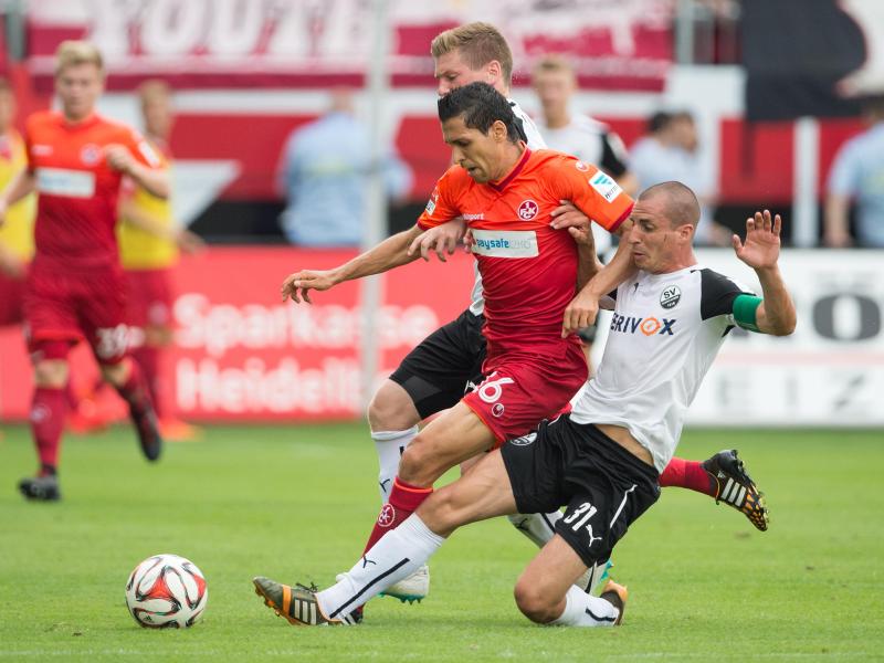 Sandhausens Denis Linsmayer (hinten) und Stefan Kulovits kämpfen mit Kaiserslauterns Karim Matmour (M.) um den Ball