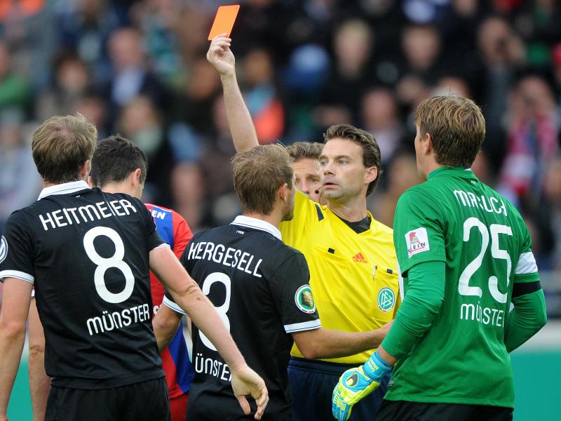 Schiedsrichter Guido Winkmann (2.v.r) zückt gegen Münsters Marc Heitmeier (l) die rote Karte. Foto: Jonas Güttler