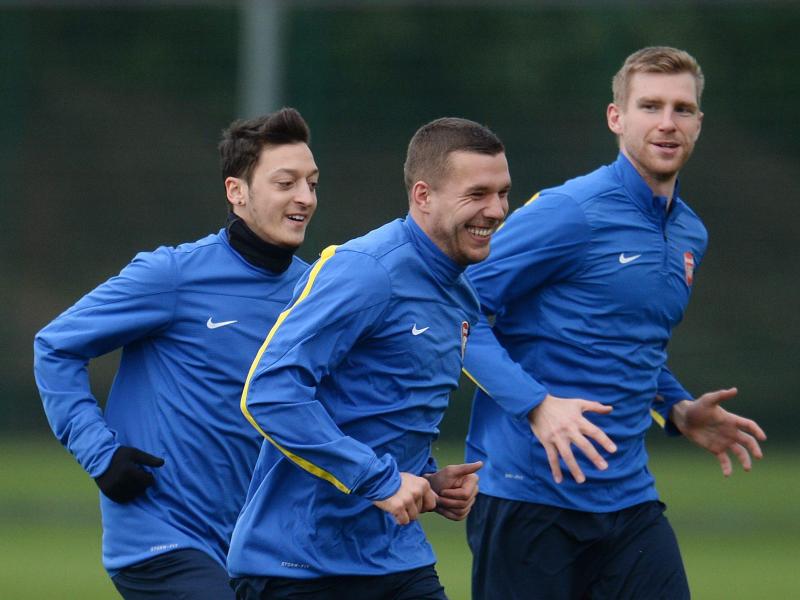 Lukas Podolski (M.) trainiert noch beim FC Arsenal mit Per Mertesacker (r.) und Mesut Özil
