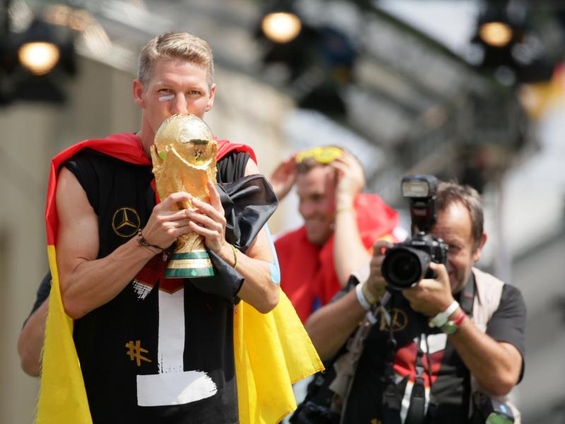 Bastian Schweinsteiger jubelt beim Empfang der Nationalmannschaft in Berlin mit dem WM-Pokal