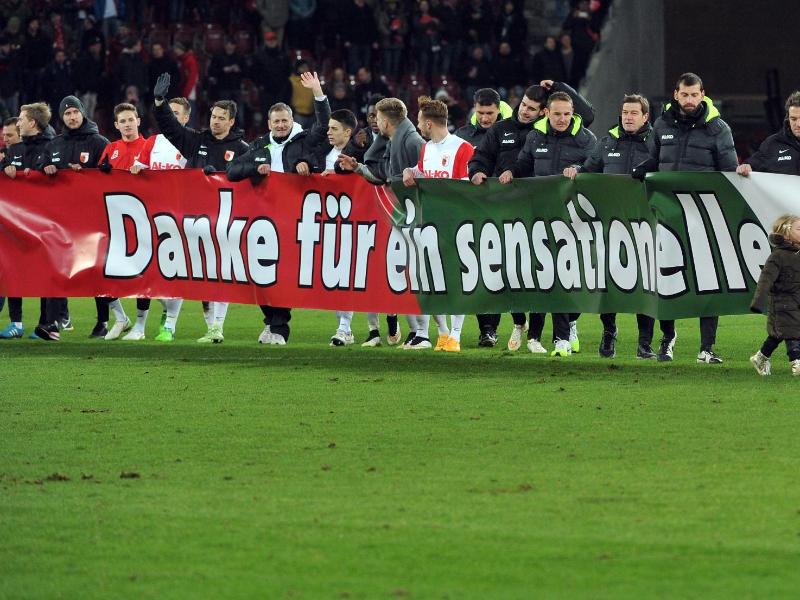 Die Augsburger Mannschaft bedankt sich mit einem Banner bei ihren Fans