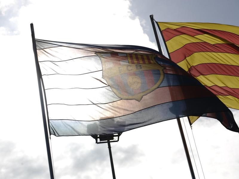 Eine Barça-Fahne und eine katalanische Flagge wehen auf dem Gelände des Camp Nou in Barcelona