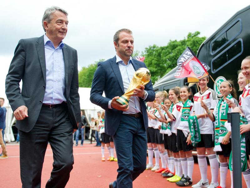 DFB-Präsident Wolfgang Niersbach (l.) und Sportdirektor Hans-Dieter Flick präsentieren eine Kopie des WM-Pokals