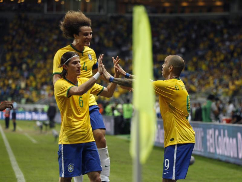 Die Brasilianer Filipe Luis (l.), David Luiz und Diego tardelli (r.) bejubeln ein Tor