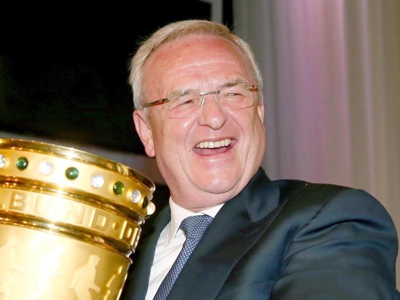 VW-Chef Martin Winterkorn strahlt mit dem DFB-Pokal um die Wette