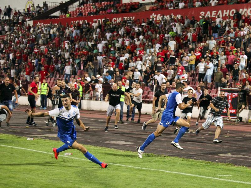 Die Spieler aus Israel (vorn) bringen sich vor den aggressiven bulgarischen Fans in Sicherheit