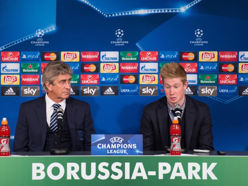 Manchesters Trainer Manuel Pellegrini (l) und Kevin de Bruyne bei einer Pressekonferenz in Mönchengladbach