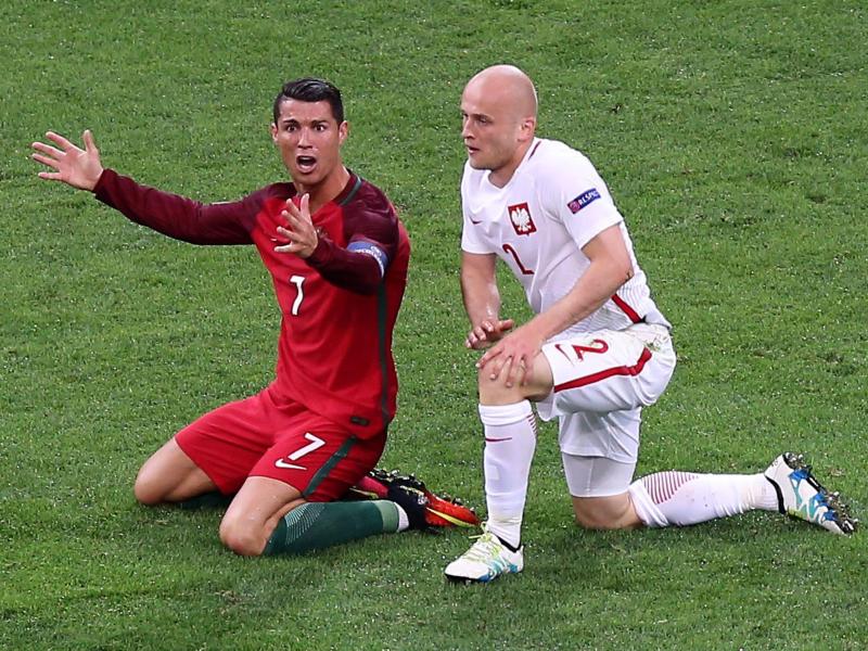 Cristiano Ronaldo (l.) beschwert sich nach einem Foul durch den Polen Michał Pazdan.