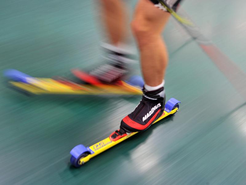 Ein Skilangläufer trainiert am Olympiastützpunkt in Oberwiesenthal mit Rollski auf einem Laufband