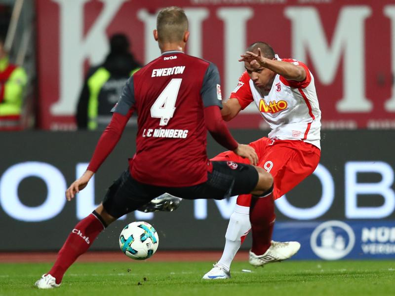 Nürnbergs Ewerton (l.) blockt im Spiel gegen Jahn Regensburg einen Ball von Jann George