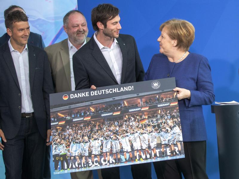 Angela Merkel (r.) bekam ein Bilder der deutschen Nationalmannschaft überreicht Angela Merkel (r.) bekam ein Bilder der deutschen Nationalmannschaft überreicht