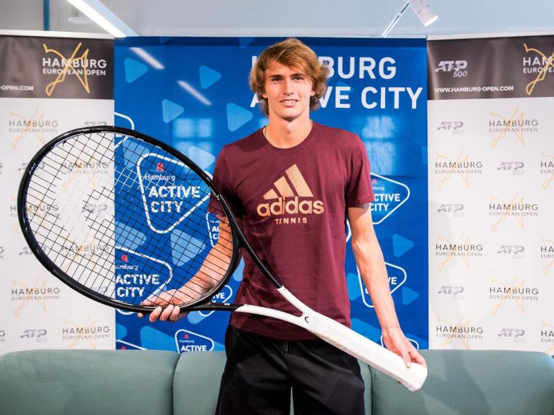 Alexander Zverev posiert in Hamburg während einer Pressekonferenz mit einem überdimensionalen Tennisschläger Alexander Zverev posiert in Hamburg während einer Pressekonferenz mit einem überdimensionalen Tennisschläger