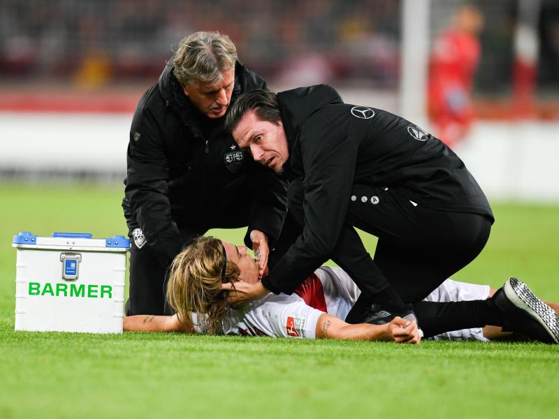 Borna Sosa vom VfB Stuttgart wird von den Mannschaftsärzten behandelt