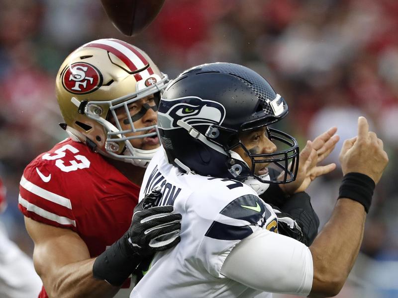 Mark Nzeocha (l) von den San Francisco 49ers in Aktion gegen Seahawks-Quarterback Russell Wilson Mark Nzeocha (l) von den San Francisco 49ers in Aktion gegen Seahawks-Quarterback Russell Wilson