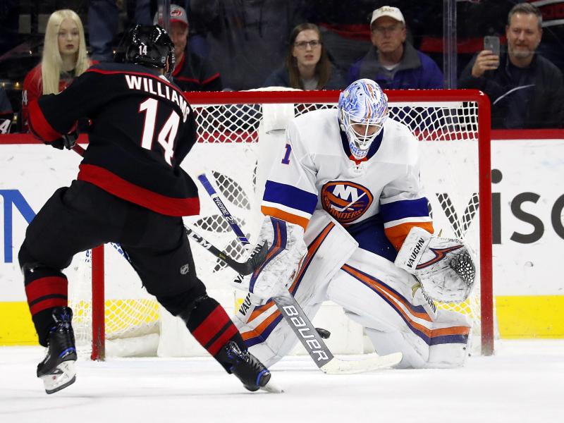 Justin Williams (l) von den Carolina Hurricanes in Aktion gegen Goalie Thomas Greiss von den New York Islanders Justin Williams (l) von den Carolina Hurricanes in Aktion gegen Goalie Thomas Greiss von den New York Islanders