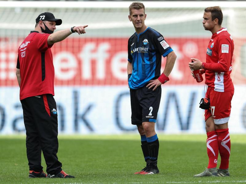 Paderborns Trainer Steffen Baumgart spricht nach dem Spiel mit Uwe Hünemeier und Torwart Leopold Zingerle (v.l.n.r.)