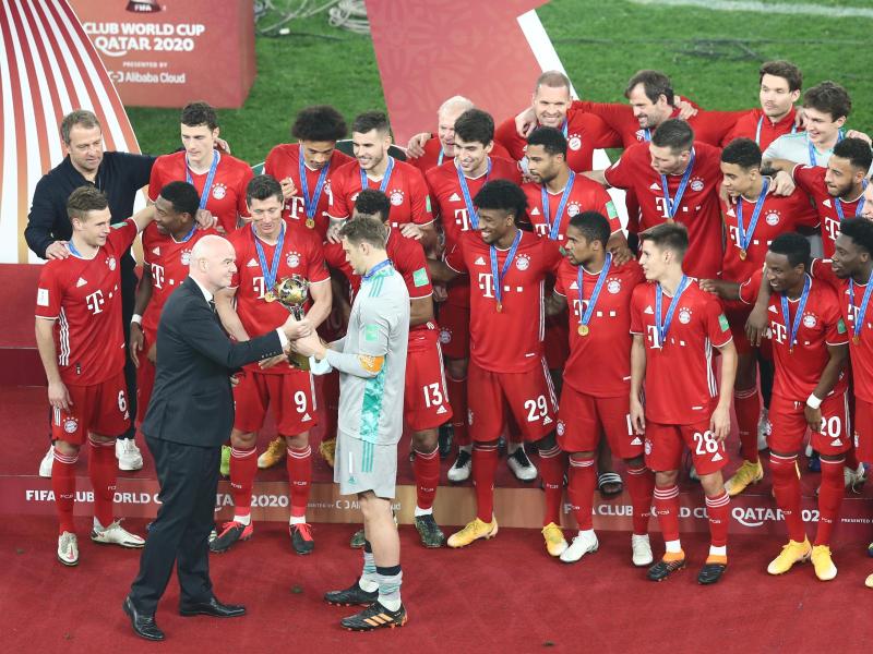 FIFA-Boss Gianni Infantino (l) überreicht Bayern-Kapitän Manuel Neuer den Pokal der Klub-WM