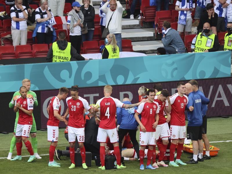 Dänemarks Spieler schirmen ihren Teamkollegen Christian Eriksen während der lebensrettenden Maßnahmen ab