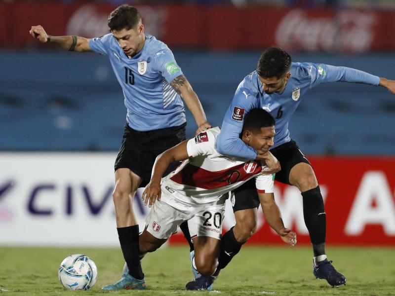 Perus Edison Flores (M) kämpft mit Uruguays Rodrigo Bentancur (r) und Federico Valverde um den Ball