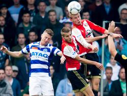 Erik van Quekel (l.) gaat het kopduel aan met Bart Nieuwkoop (m.) en Sven van Beek (r.), maar komt niet hoog genoeg om de bal te koppen. (04-10-2015)