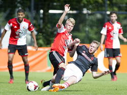 Jari Schuurman (l.) wordt hard aangepakt door Ajacied Nathan Leyder in het duel Feyenoord A1 - Ajax A1. (23-08-2014)