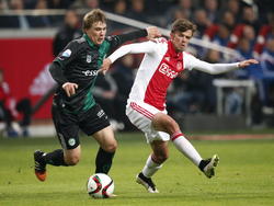 Nieuwbakken Groningen-middenvelder Simon Tibbling duelleert met Ajax-middenvelder Lucas Andersen. (16-01-2015)