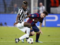 Paul Pogba (l.) gebruikt goed zijn lichaam om Lionel Messi van de bal te zetten tijdens de Champions League-finale tussen Juventus en FC Barcelona. (06-06-2015)