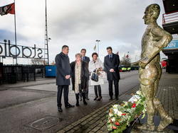 De directie van Feyenoord legt samen met de weduwe van Coen Moulijn (tweede van links) een krans op het standbeeld van de legende van Feyenoord. (04-01-2015)