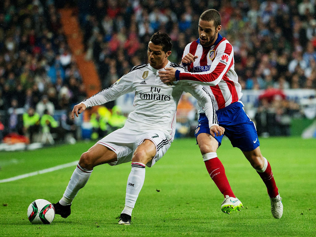 Cristiano Ronaldo (l.) probeert Mario Suárez (r.) van zich af te houden tijdens het bekerduel Real Madrid - Atlético Madrid. (15-01-2015)