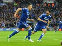 John Terry (l.) rent samen met Diego Costa juichend weg nadat hij Chelsea op voorsprong heeft gezet tijdens de League Cup-finale tegen Tottenham Hotspur. (01-03-2015)