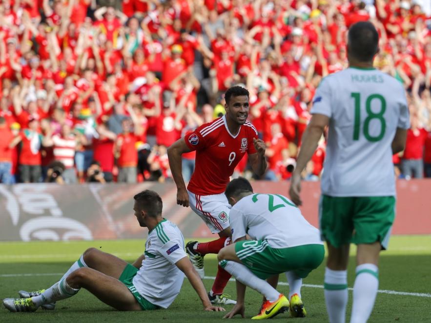 Gareth McAuley (l.) heeft zojuist de bal in zijn eigen doel geschoten tijdens het EK-duel Wales - Noord-Ierland (25-06-2016).