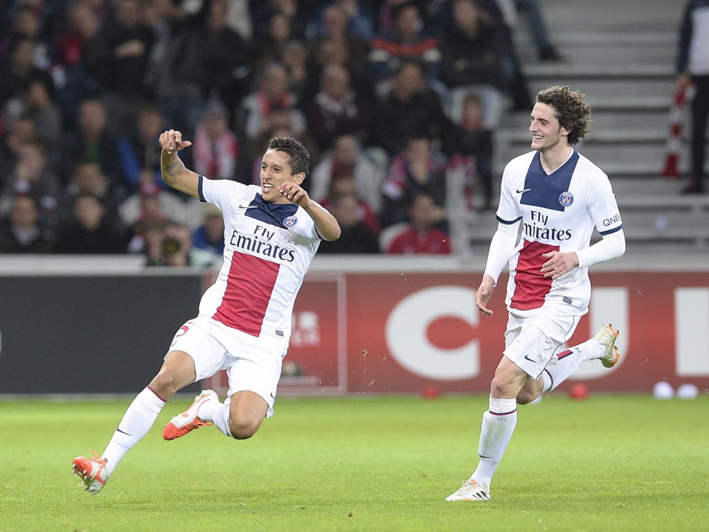 Marquinhos (l.) juicht nadat hij de score heeft geopend tegen Lille OSC. Adrien Rabiot (r.) doet vrolijk mee. (10-05-2014)