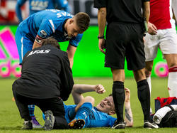 Markus Henriksen (l.) neemt een kijkje bij Mattias Johansson, die na een luchtduel in de wedstrijd Ajax - AZ. heel vervelend terechtkwam. (28-02-2016)