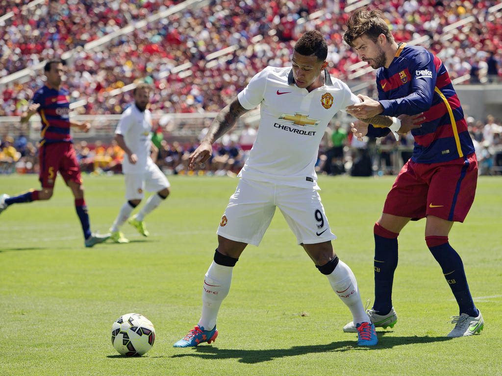 Memphis Depay (l.) krijgt in de oefenwedstrijd tussen Manchester United en FC Barcelona te maken met Gerard Piqué. (25-07-2015)