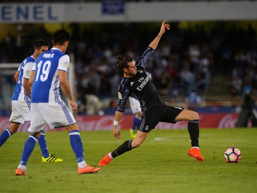 Een acrobatische manoeuvre van Gareth Bale (r.) tijdens de openingswedstrijd van het seizoen in Sociedad. (21-08-2016)
