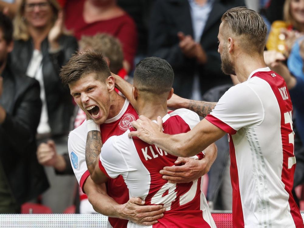 Klaas-Jan Huntelaar (l.) is blij met zijn eerste treffer in de Eredivisie sinds zijn rentree bij Ajax. De spits heeft zojuist met zijn hoofd gescoord tegen FC Groningen. Justin Kluivert (m.) en Mitchell Dijks (r.) vieren de kopgoal met de aanvaller mee. (20-08-2017)