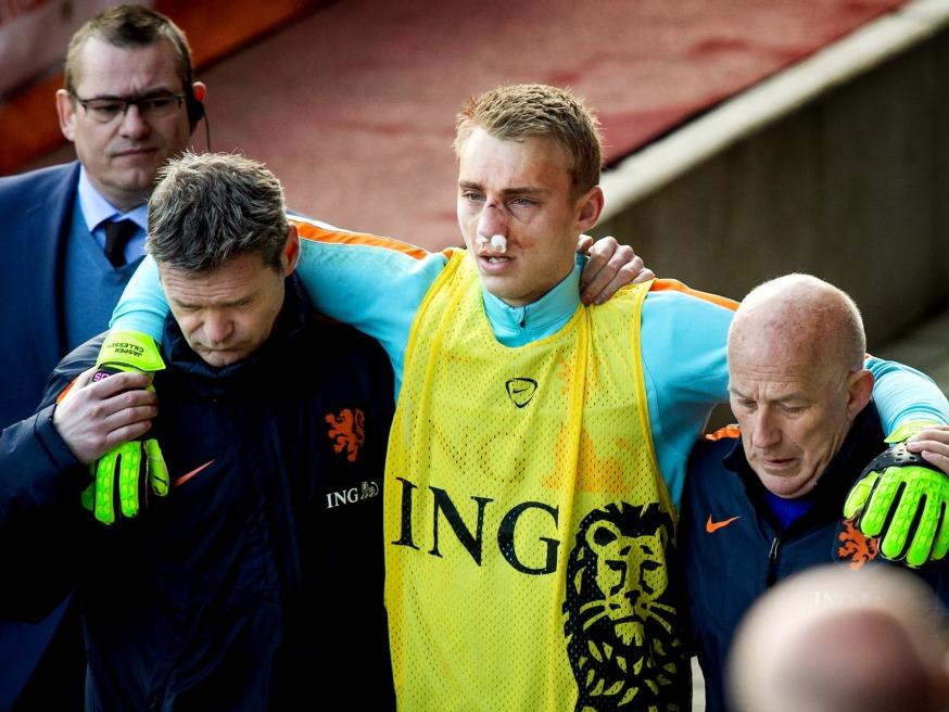 Met een zeer gehavend gezicht wordt Jasper Cillessen van het veld geholpen. De goalie van Ajax breekt zijn neus op de training van het Nederlands elftal na een botsing. (27-03-2016)