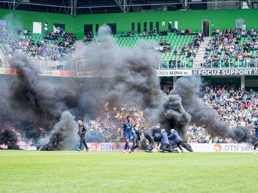 Fans des FC Groningen werfen während des Spiels Rauchbomben auf das Spielfeld.