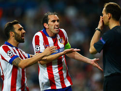 Diego Godín (m.) en Jesús Gámez (l.) zijn het tijdens Real Madrid - Atlético Madrid niet eens met een beslissing van de arbitrage. (22-04-2015)