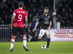 Luuk de Jong (l.) kijkt toe hoe Robin Pröpper de bal naar een medespelers speelt. (15-10-2016)
